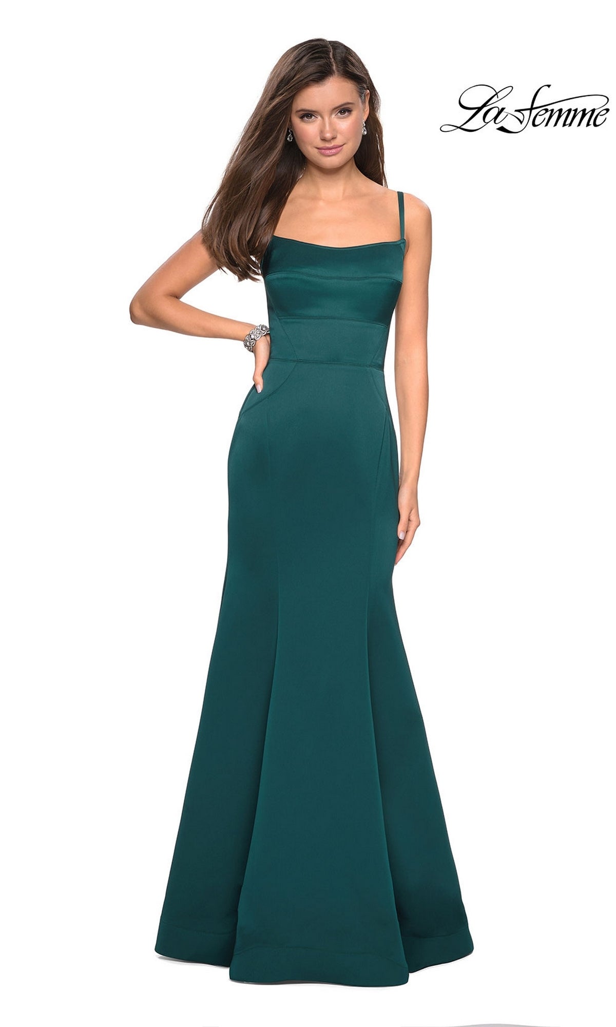 A woman wears the La Femme Square-Neck Simple Long Prom Dress 27524, a sleeveless, floor-length dark teal gown with a fitted bodice and elegant mermaid skirt, posing with one hand on her hip.